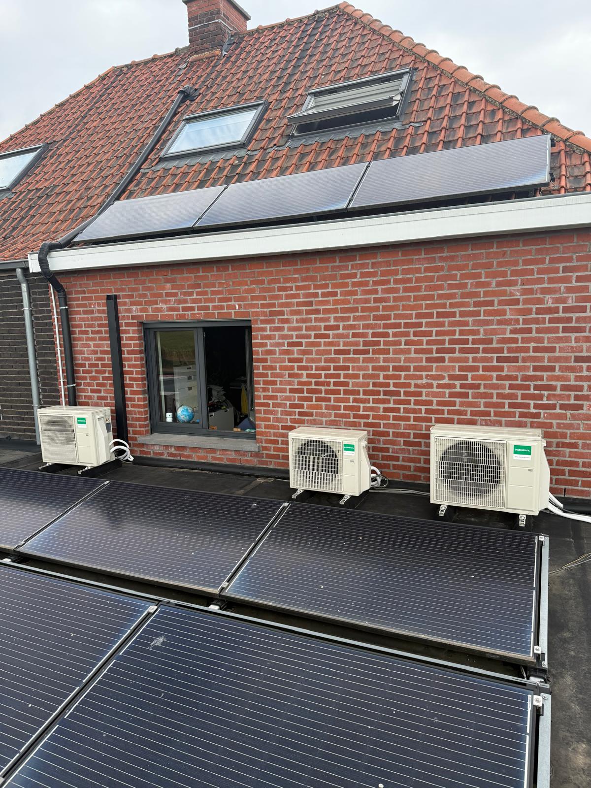 Drie airco-buitenunits op het platte dak naast de zonnepanelen van de woning in Elsegem