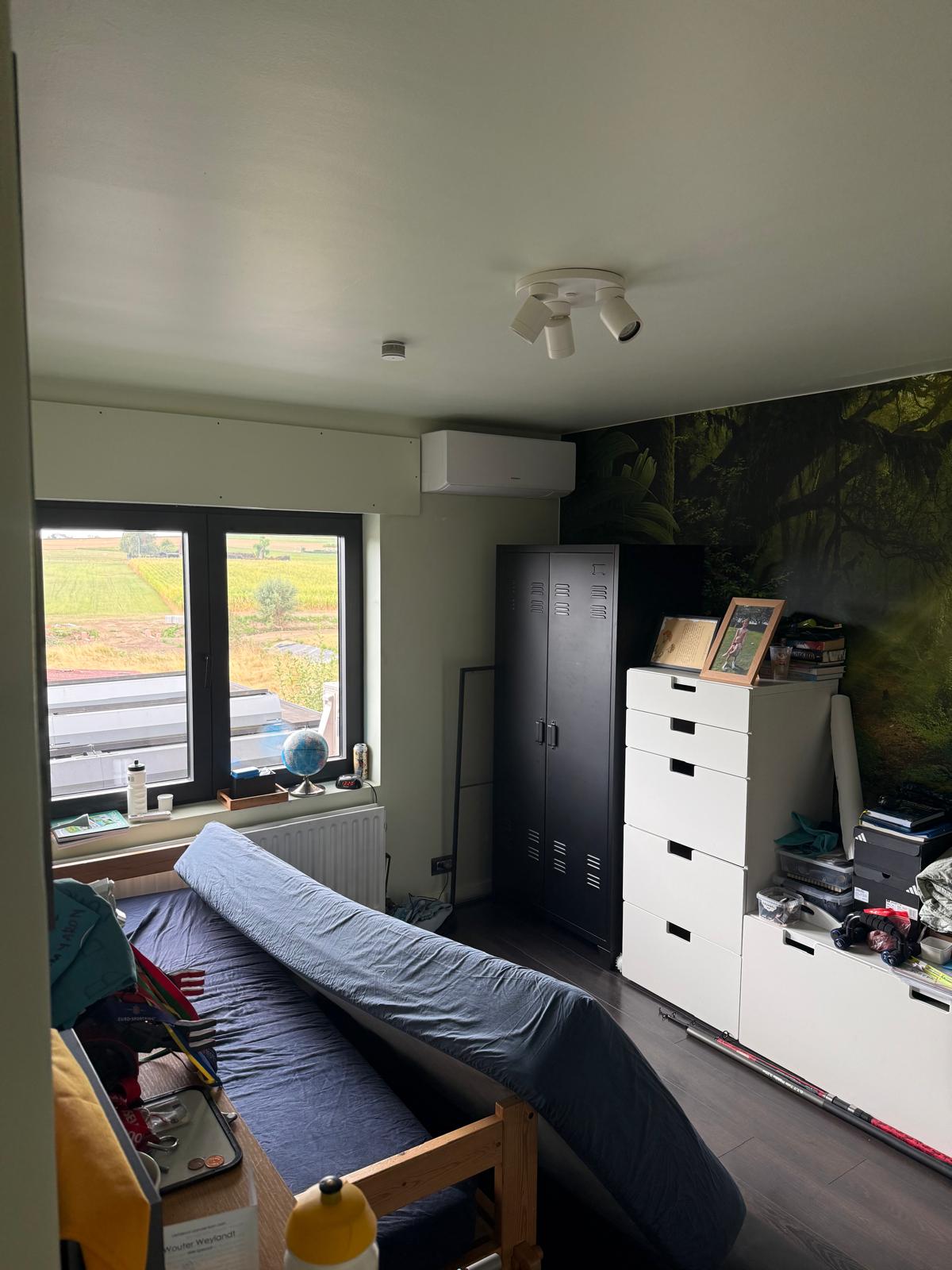Binnenunit van de airco boven het raam in een slaapkamer van de woning in Elsegem